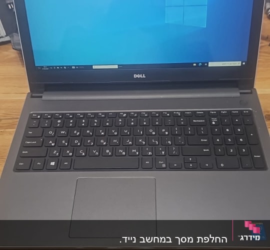 מחשב נייד דל עם מסך פתוח על שולחן עץ